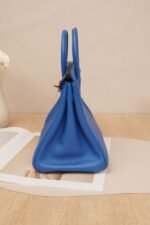 Side view of a Hermès Birkin 25 bag in Bleu Brume Togo leather with gold hardware