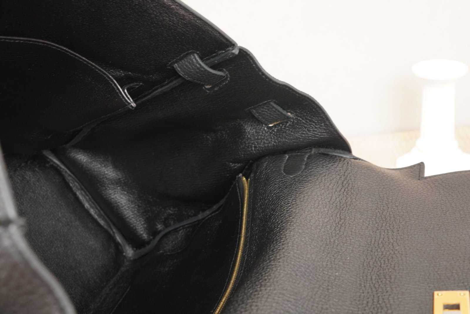 Close-up detail of a black Hermès Kelly 35 bag with gold hardware