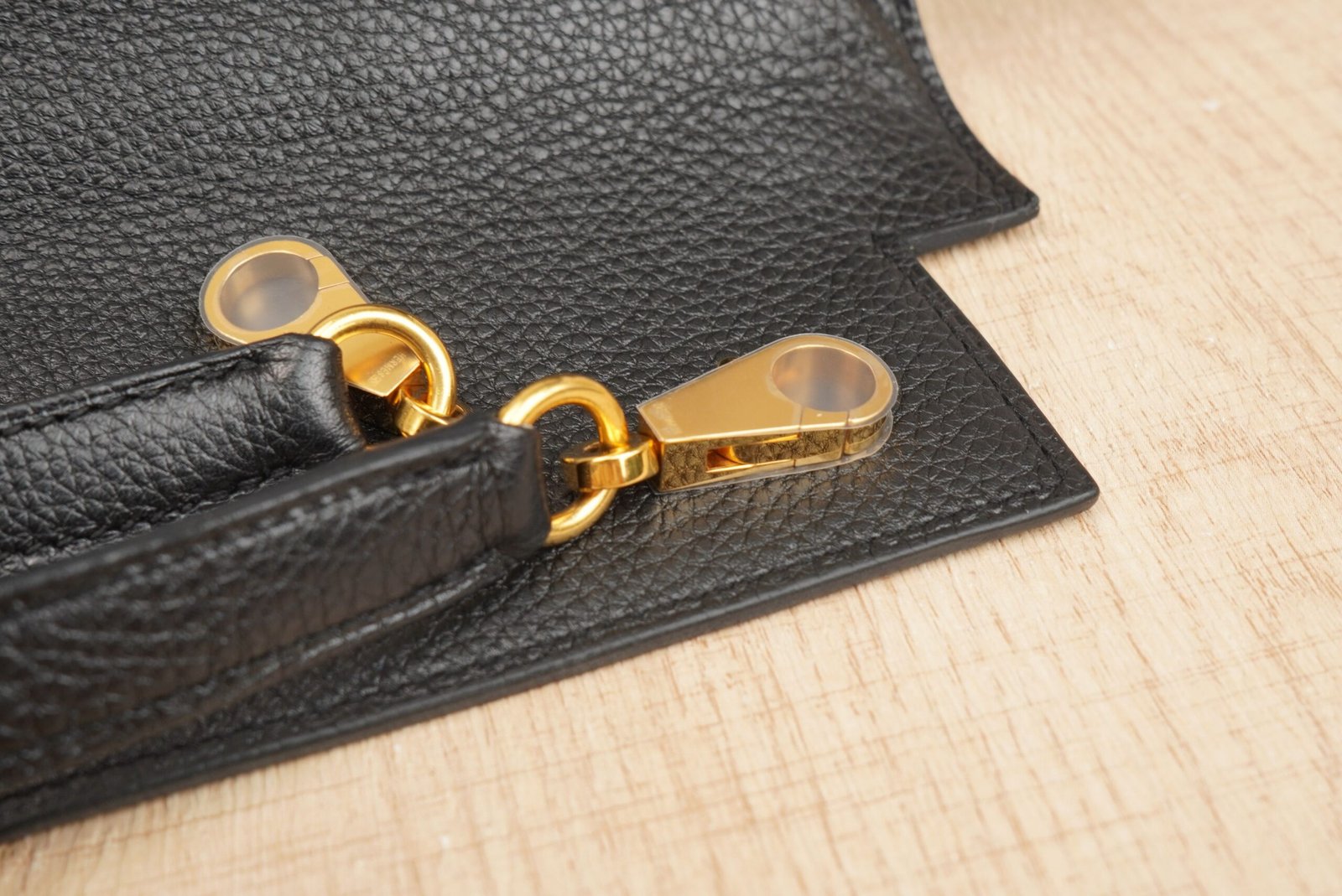 Black Hermès Kelly 35 handbag with gold hardware on a surface
