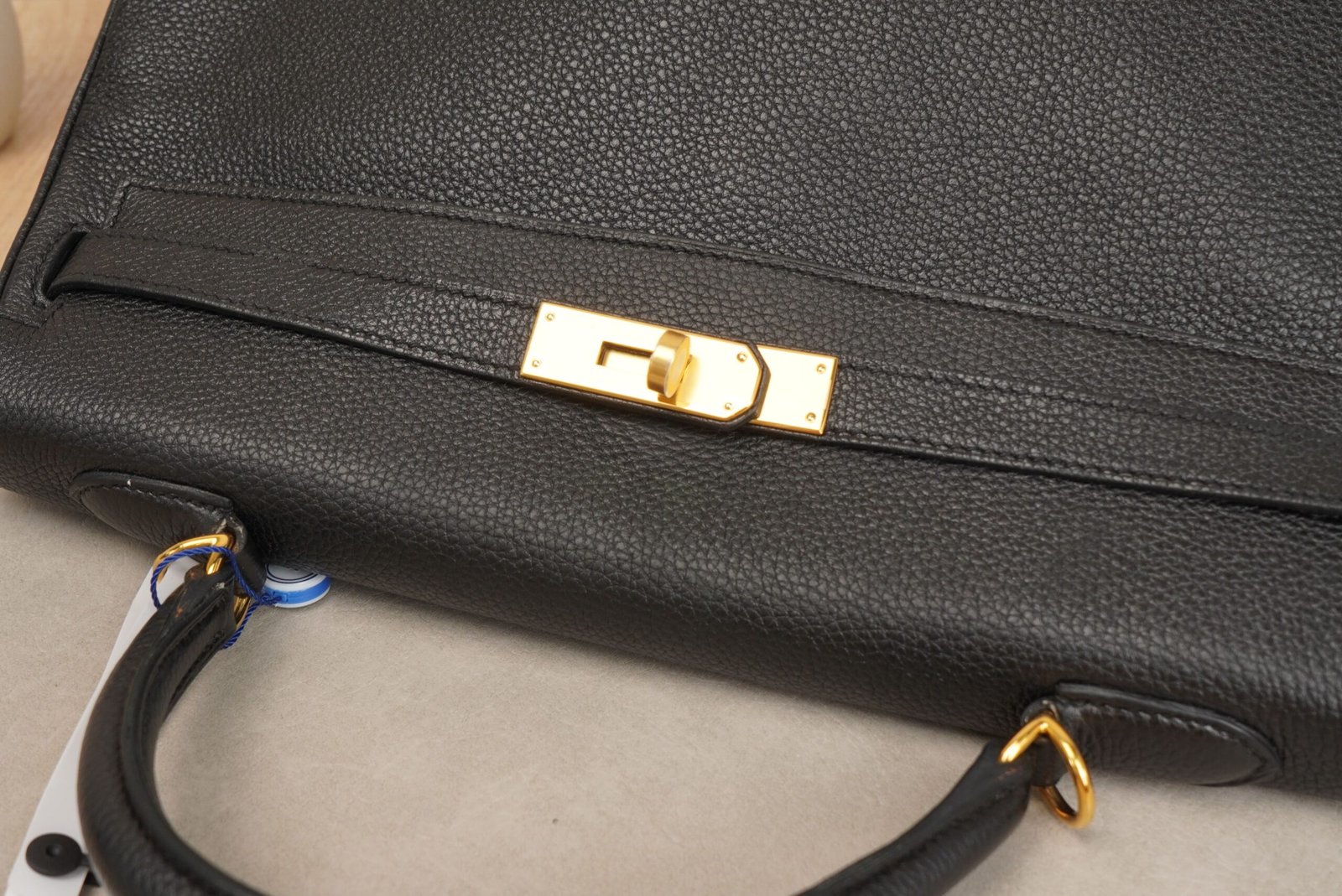 Black Hermès Kelly 35 handbag with gold hardware on a surface