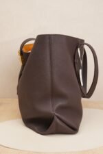Side view of a burgundy Louis Vuitton tote bag